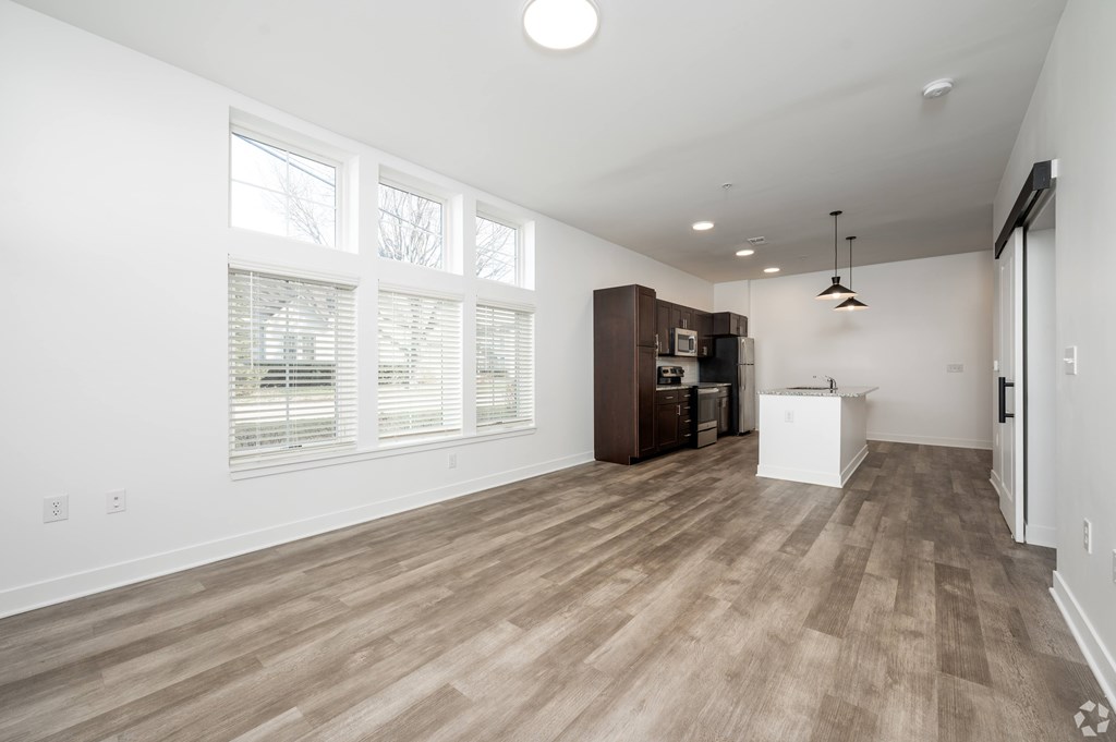 A room with wooden flooring and a large window.