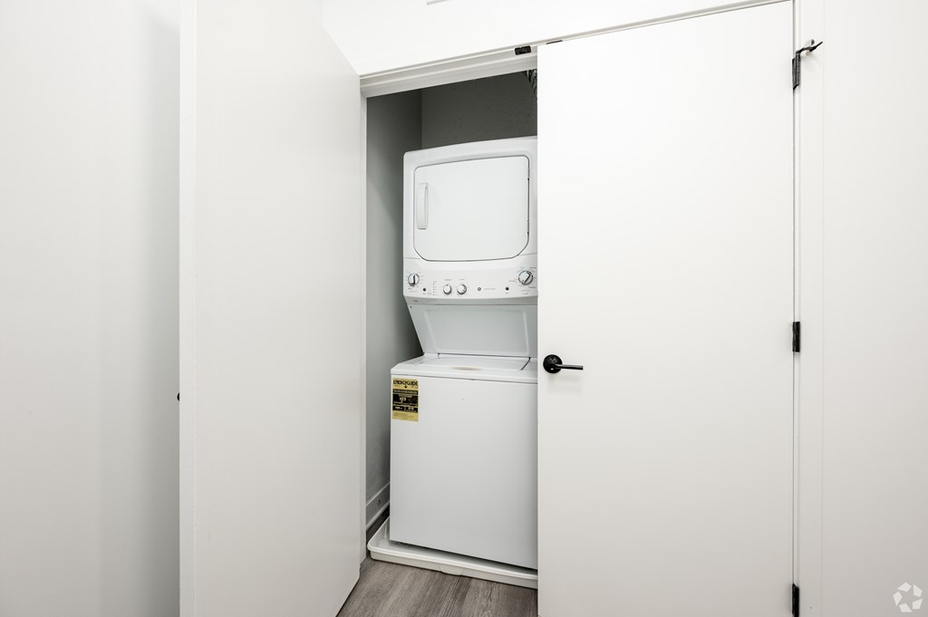 A white washing machine is in a small laundry room.