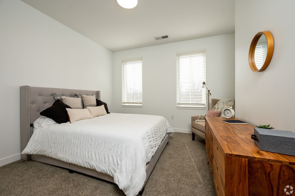 A bedroom with a large bed and a wooden desk.