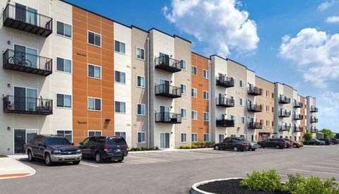 an apartment building with cars parked in front of it