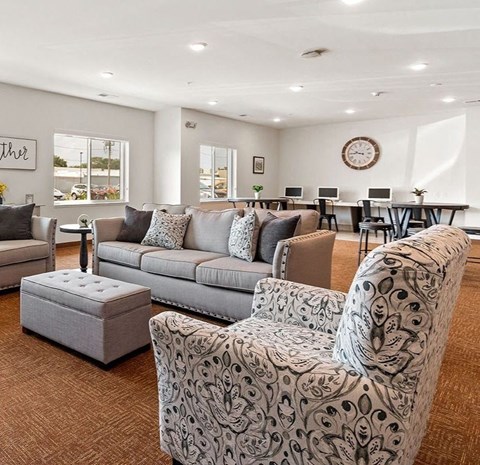 A living room with a grey couch and a patterned armchair.