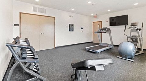 a gym with exercise equipment and a tv