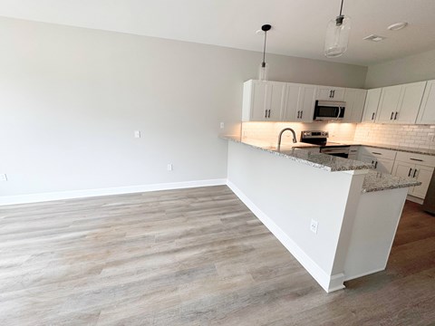 A kitchen with a white countertop and cabinets.