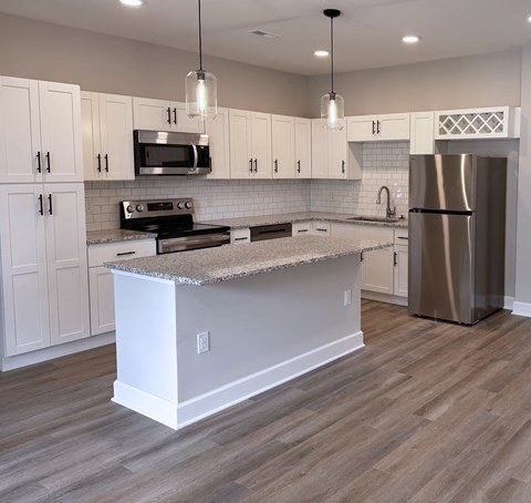 A modern kitchen with a central island and stainless steel appliances.