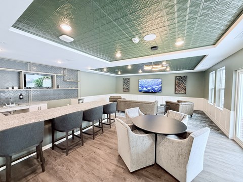 A modern dining room with a bar area and a television mounted on the wall.