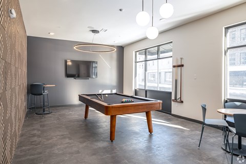 A room with a pool table and a television.