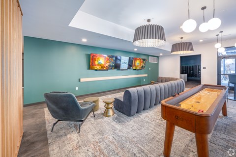 A room with a pool table and a row of chairs.
