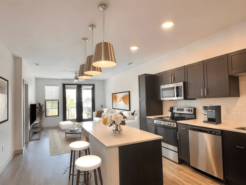 A modern kitchen with dark brown cabinets and a white island.