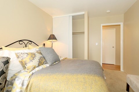 A bedroom with a bed and a lamp.