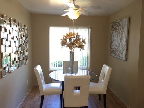 A dining room with a table and chairs.