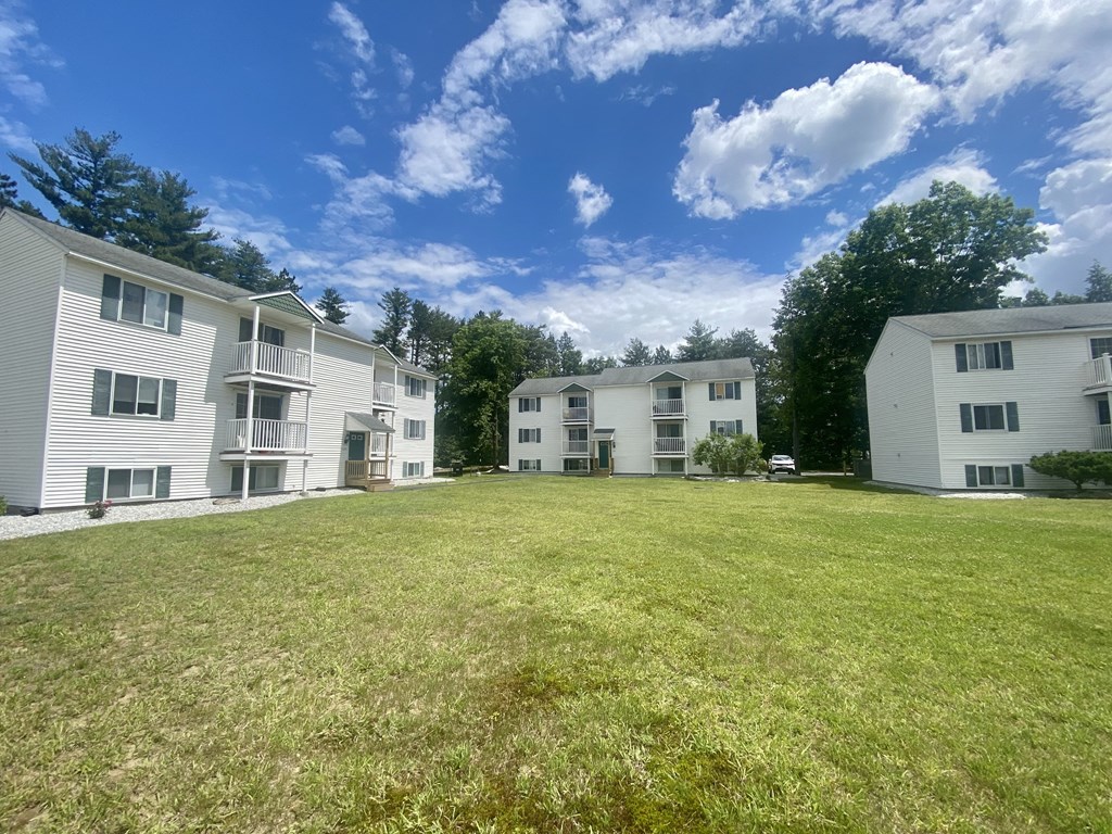 a large grassy yard between two apartment buildings