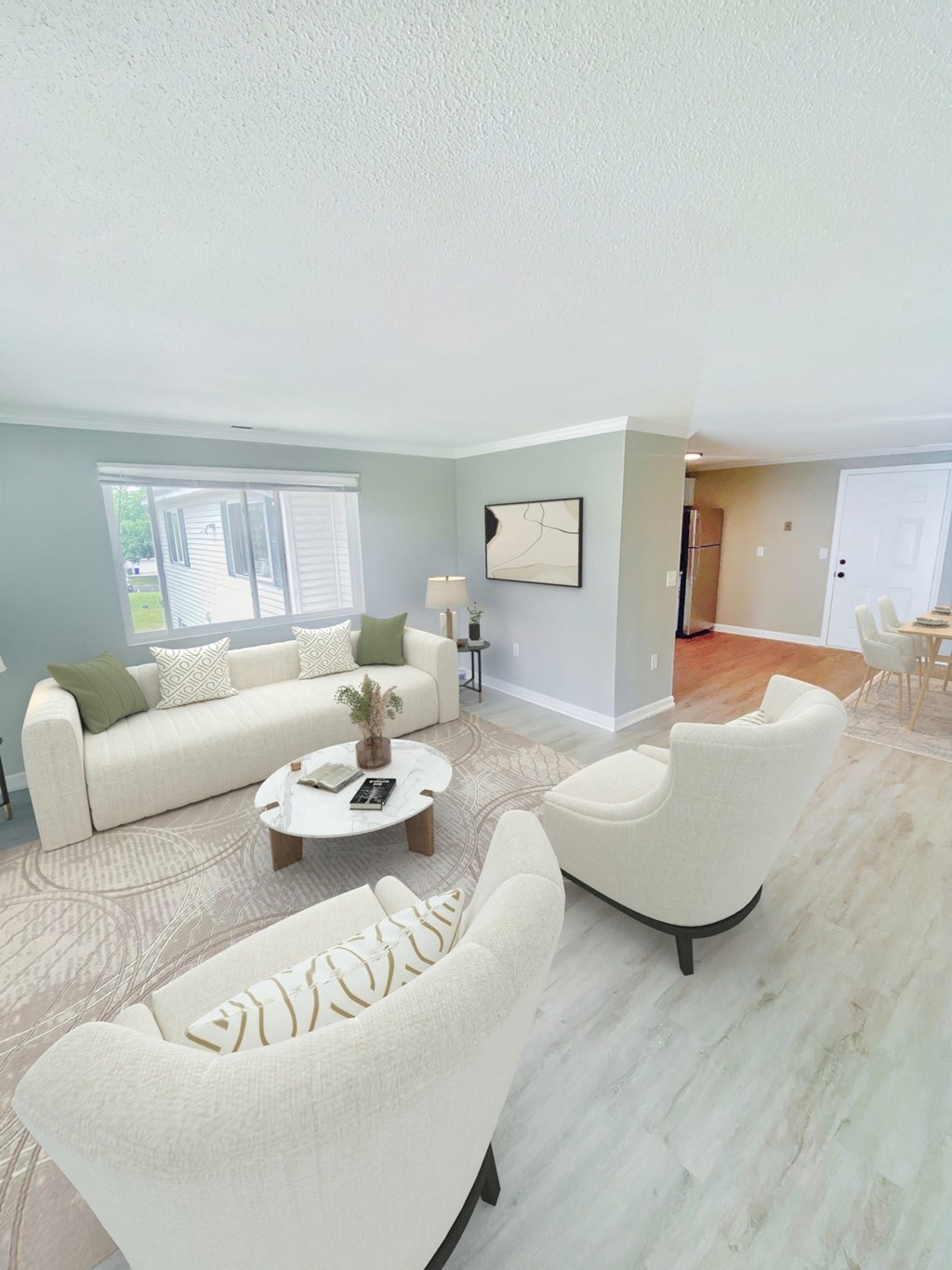 a living room with white couches and chairs and a rug