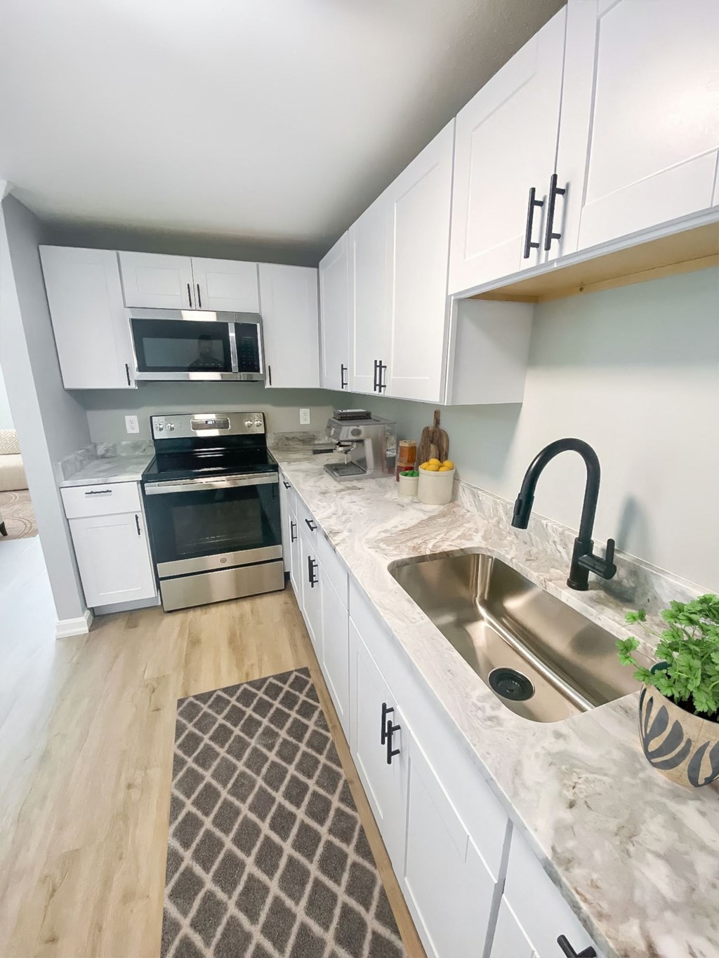 a kitchen with white cabinets and stainless steel appliances and a sink