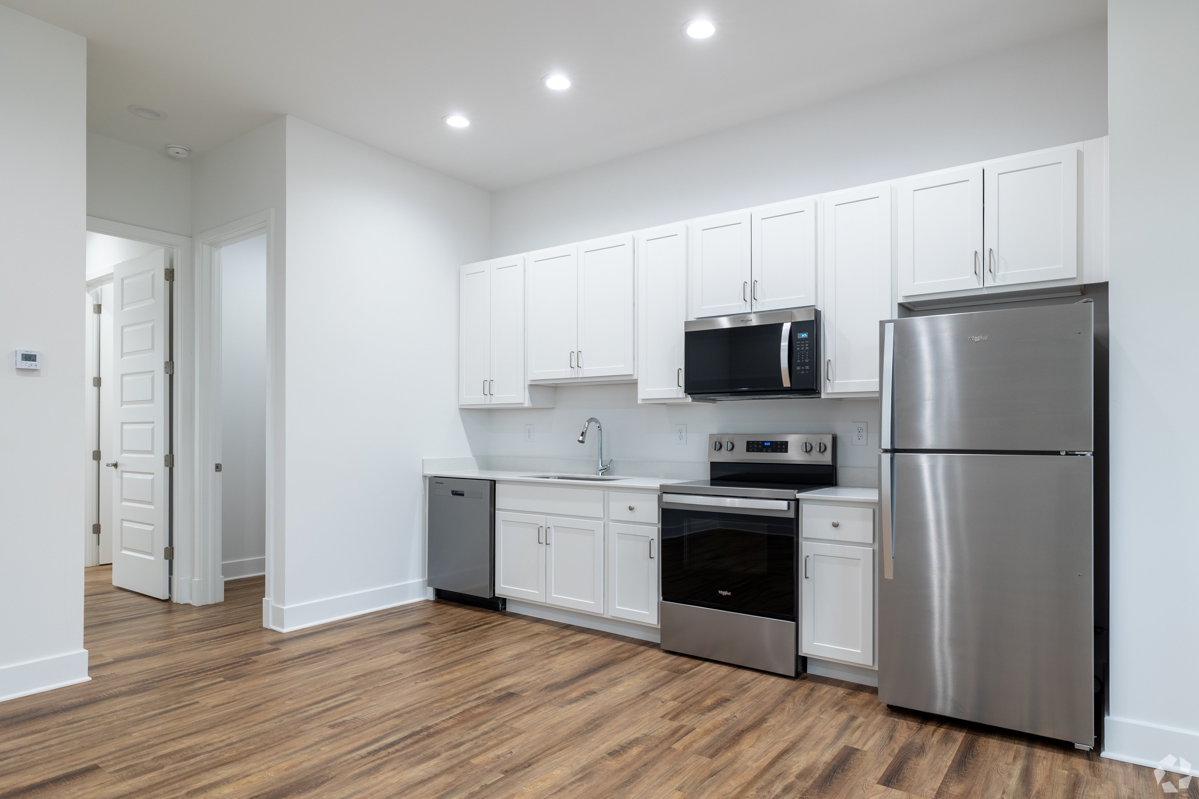 A kitchen with white cabinets and stainless steel appliances.