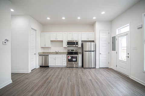 A modern kitchen with white cabinets and stainless steel appliances.
