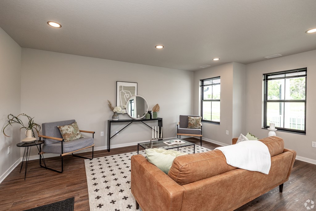 A living room with a brown couch and a grey chair.