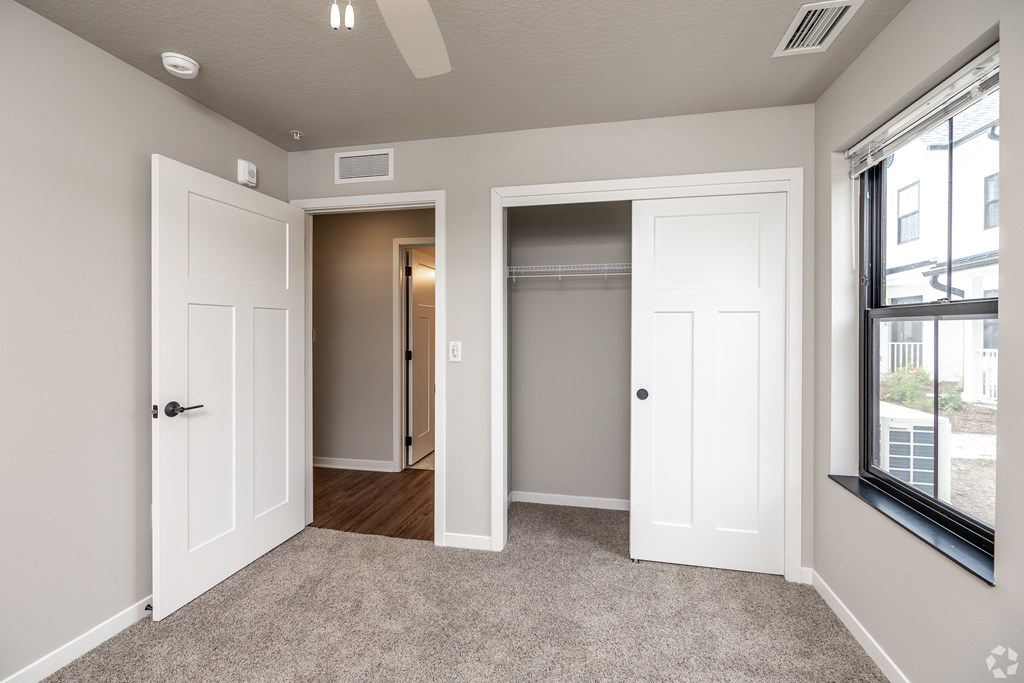 A room with a carpeted floor and a window on the right side.