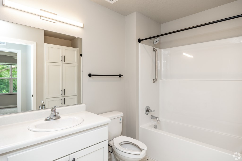 A white bathroom with a toilet, sink, and bathtub.