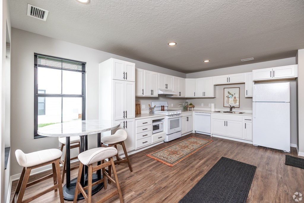 A kitchen with white cabinets and a black and white checkered floor.