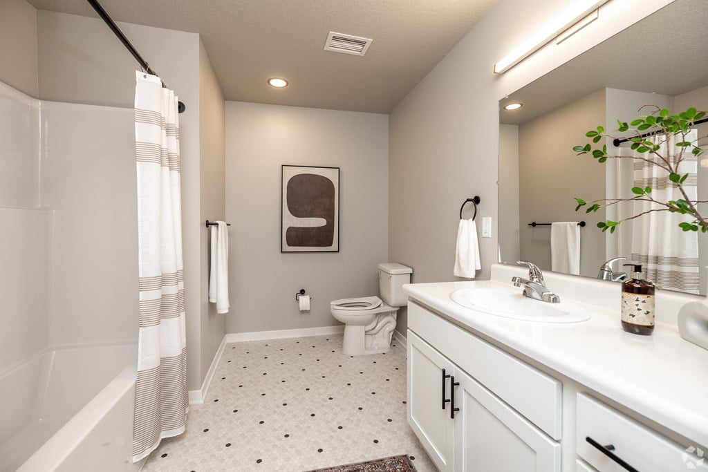 A bathroom with a toilet, sink, and shower.