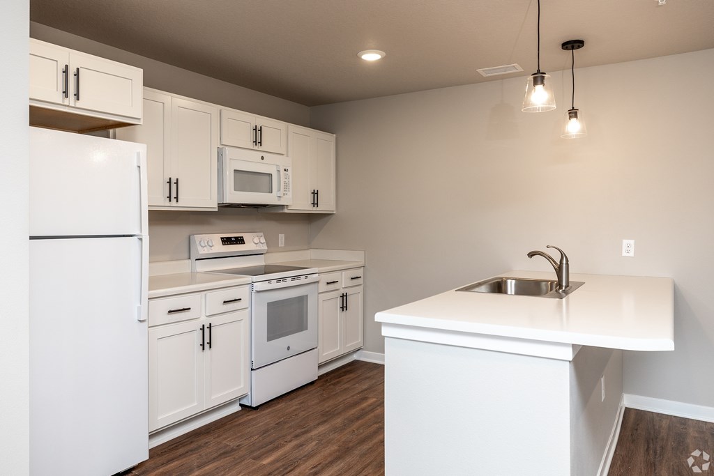 A kitchen with white appliances and cabinets.