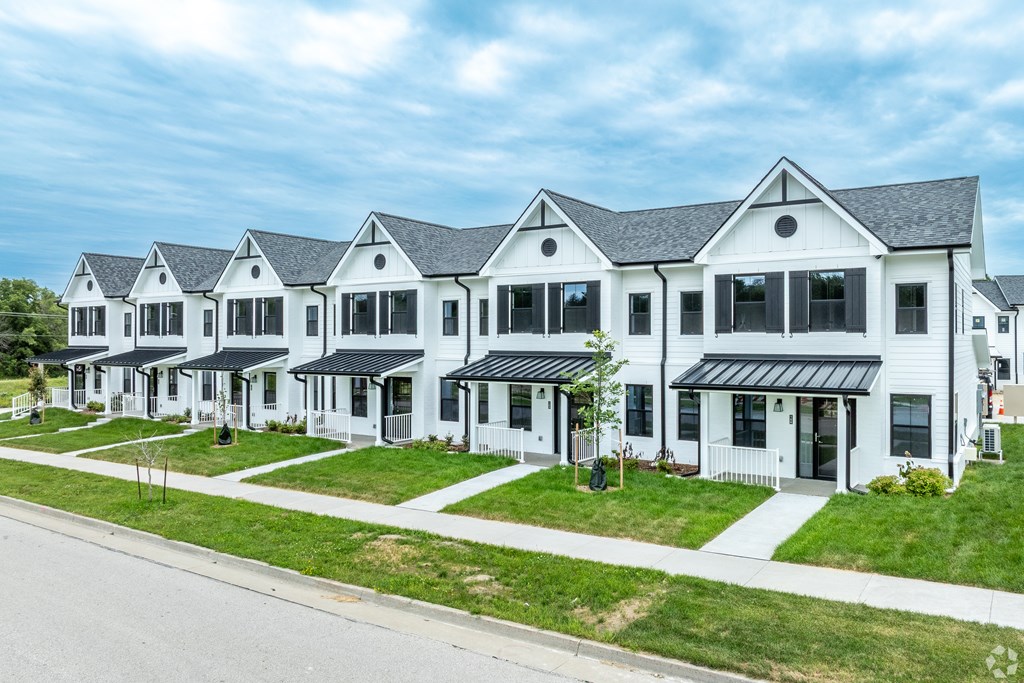 A row of white houses with black roofs and windows.