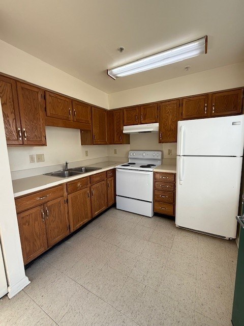 A kitchen with wooden cabinets and white appliances.