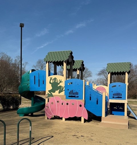 A colorful playground with a slide, swings, and a climbing structure.
