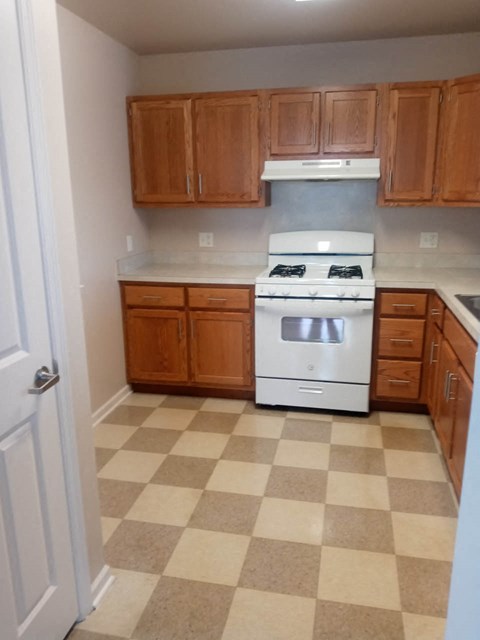 A kitchen with a checkered floor and a white oven.