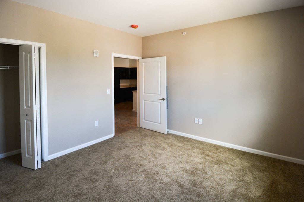 A room with a white door and a carpeted floor.at Union at 16th, Indianapolis Indiana