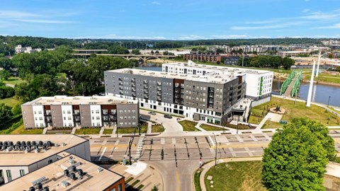 Aerial view of modern apartment buildings along riverfront at Union at Rivers Edge Apartments, Des Moines, IA, 50315