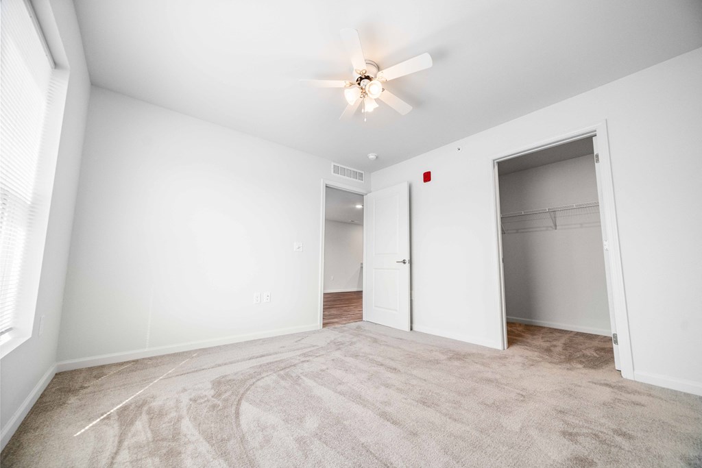a bedroom with white walls and carpet  at Union at Wiley, Cedar Rapids, Iowa