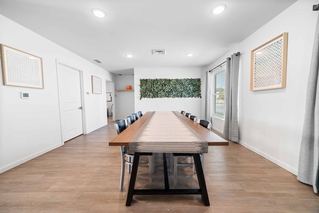 a long wooden table with black chairs in a room with white walls  at Union at Wiley, Iowa, 52404
