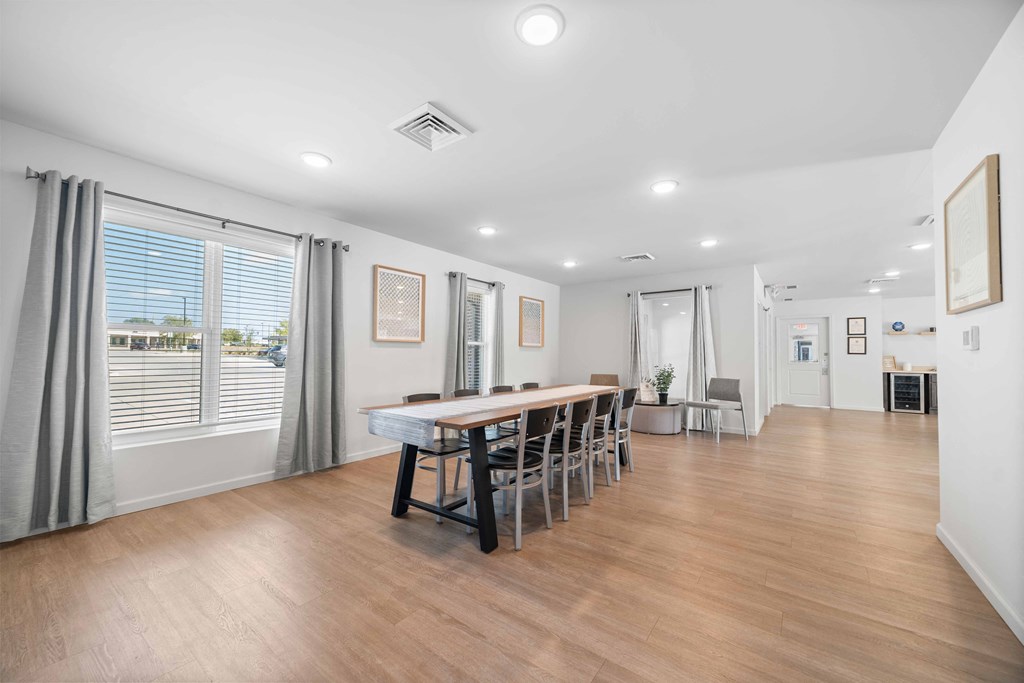 a dining room with a long wooden table and chairs  at Union at Wiley, Cedar Rapids, IA, 52404