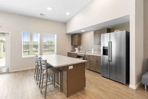 A kitchen with a table and chairs and a refrigerator.