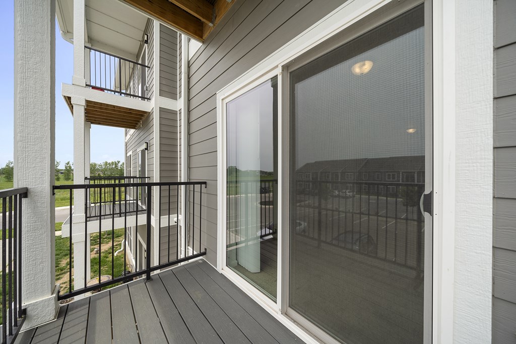 A balcony with a glass door and a black railing. at Union at the Loop, Lawrence, KS, 66046