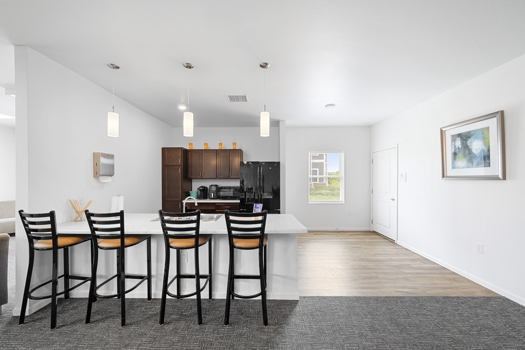 A kitchen with a bar area and chairs. at Union at the Loop, Lawrence, KS, 66046