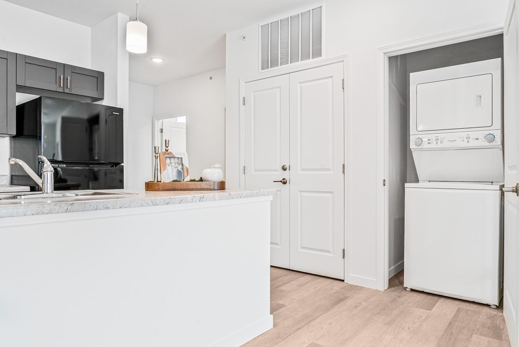 A modern kitchen with white appliances and cabinets. at Union at Oak Grove, Howell, Michigan