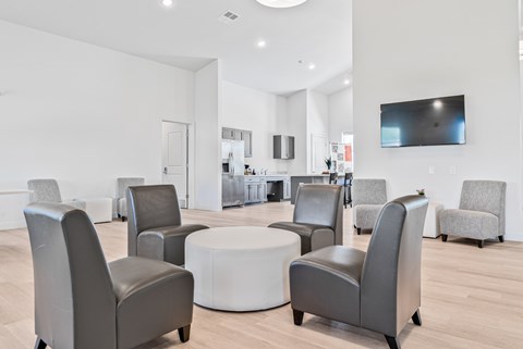 A modern living room with grey chairs and a white coffee table.