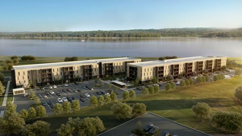 A large building complex with a parking lot in front of it.