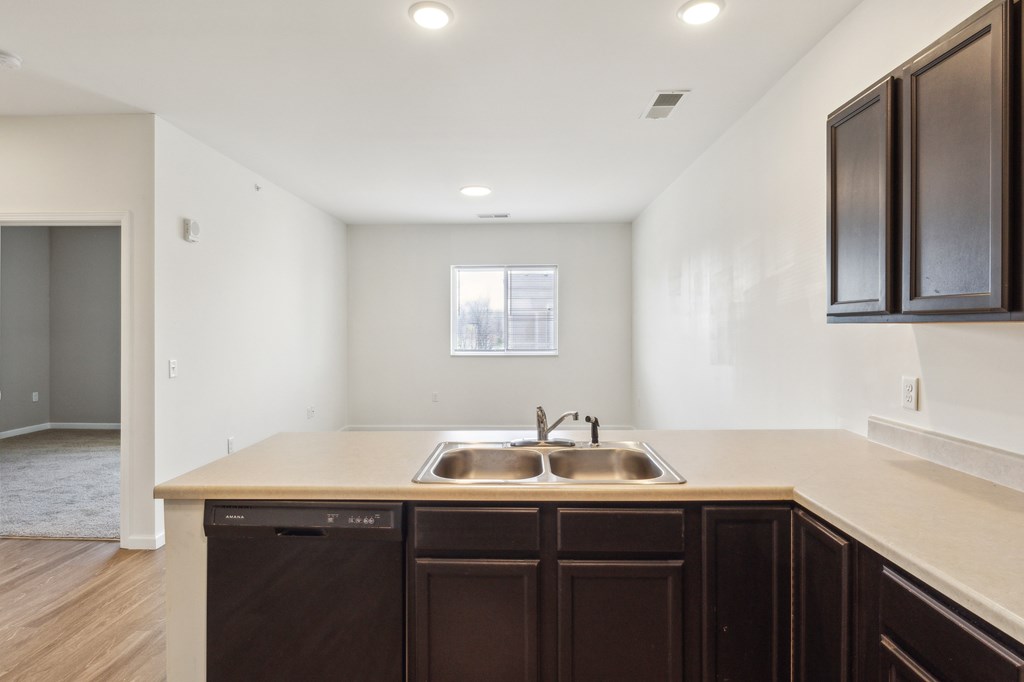 A kitchen with brown cabinets and a sink at Union at 16th, Indianapolis, IN