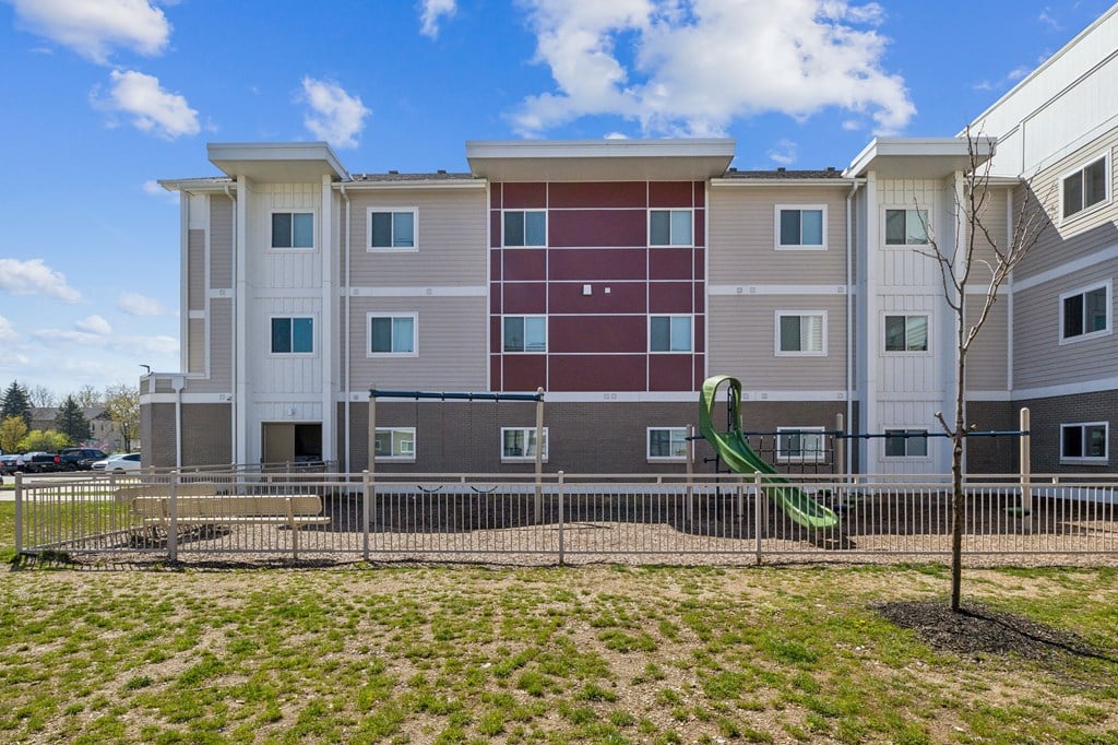 Apartment building with a playground in front at Union at 16th, Indianapolis, IN