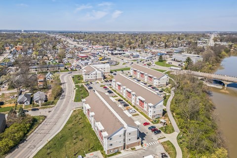 A river flows through a town with apartment buildings on the right at Union at 16th, Indianapolis, IN