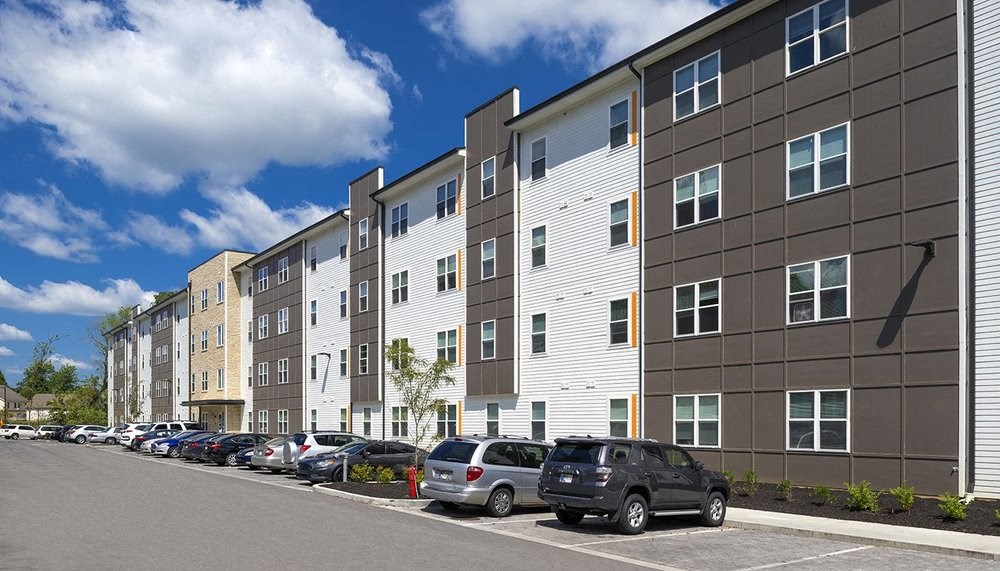 A row of modern apartment buildings with cars parked in front.at Union at Crescent, Bloomington, 47404  