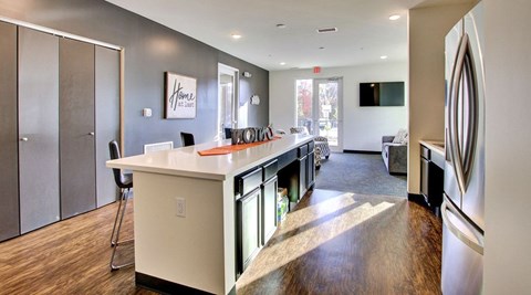 A kitchen with a white counter top and a fridge on the right.