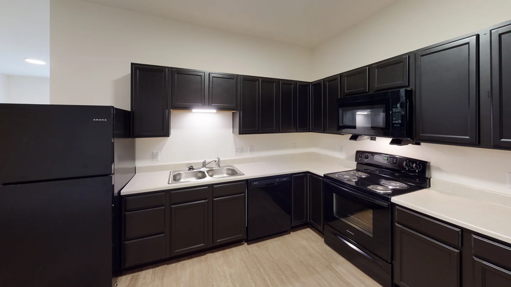 A kitchen with black cabinets and appliances.at Union at 16th, Indianapolis Indiana