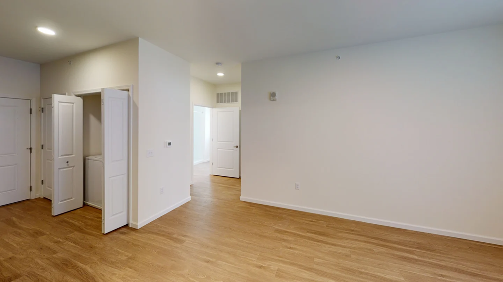 A room with white walls and wooden floors with a few doors open.at Union at 16th, Indianapolis, IN 46222