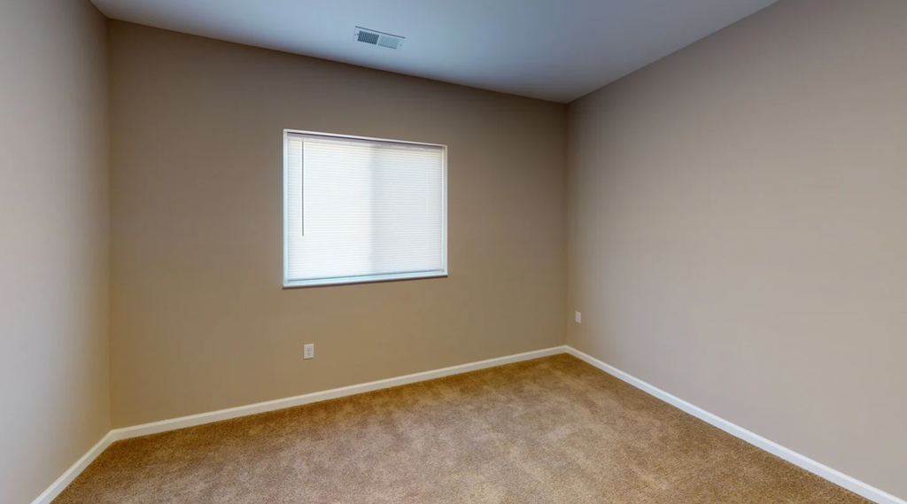 A room with a window and carpeted floor at Union at 16th, Indianapolis