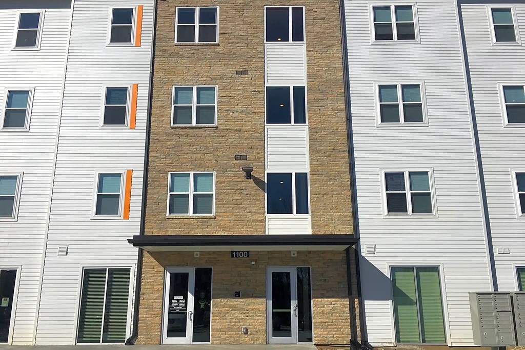 A building with a brown brick facade and white siding. A building with a brown brick facade and white siding.at Union at Crescent, Bloomington, IN 47404
