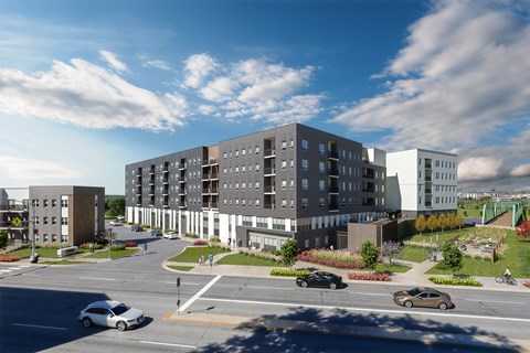 A modern apartment complex with cars parked in front.